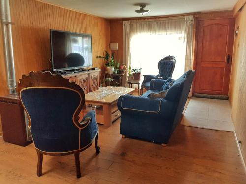 a living room with two chairs and a tv at Donde Damaris in Punta Arenas