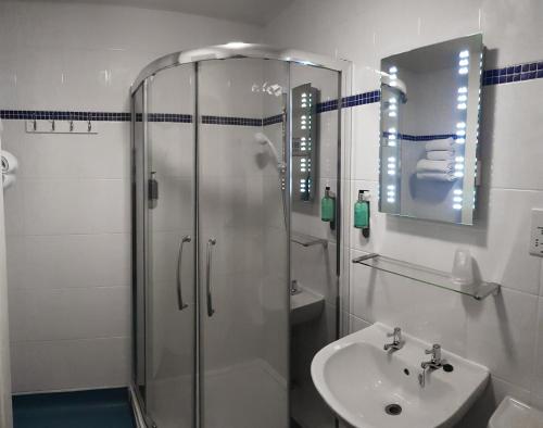 a bathroom with a shower and a sink at Dorset Resort Hotel in East Stoke