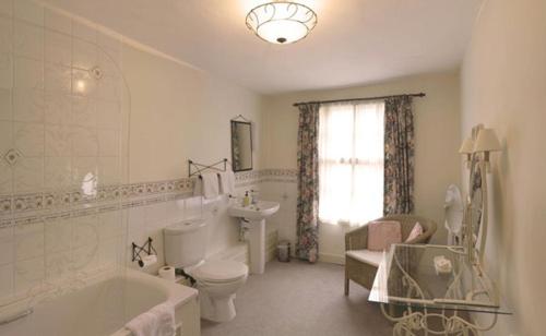a bathroom with a tub and a toilet and a sink at Bath Place Hotel in Oxford
