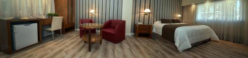 a hotel room with a bed and a desk at Gran Hotel Skorpios in Mar del Plata