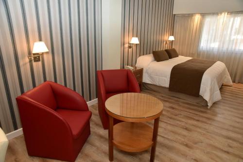 a hotel room with a bed and a table and chairs at Gran Hotel Skorpios in Mar del Plata