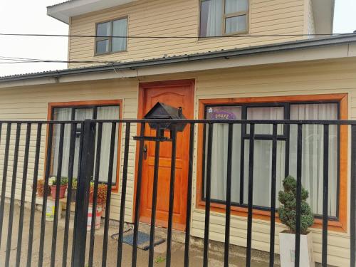 a bird perched on a fence in front of a house at Donde Damaris in Punta Arenas