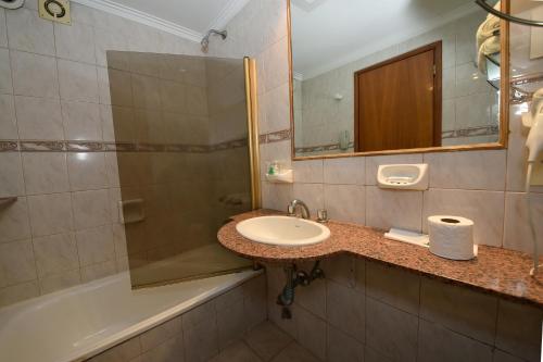 
a bathroom with a sink, toilet and bathtub at Gran Hotel Skorpios in Mar del Plata
