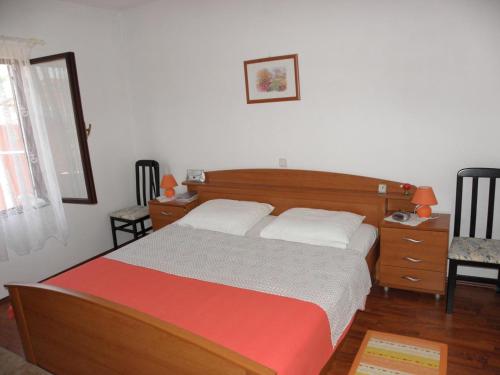 een slaapkamer met een bed, een bureau en een stoel bij Apartments Kuce - 150m from the beach with parking in Sušica