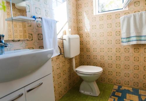 a bathroom with a toilet and a sink at Apartments AnteV - 80m from the sea in Sevid