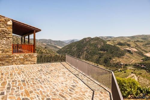 Ribalonga的住宿－Terraços de Baco，阳台,位于山间房屋的背景中