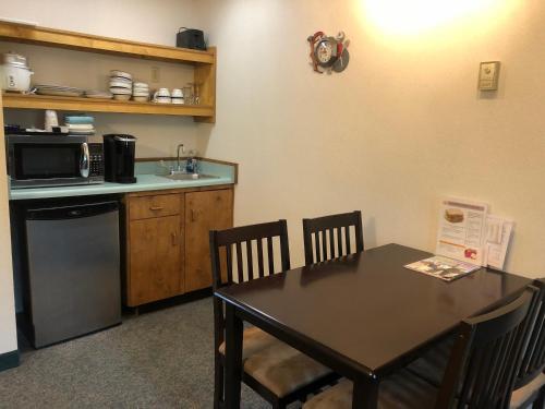 een keuken met een tafel en een magnetron en een tafel en stoelen bij Aurora Denali Lodge in Healy