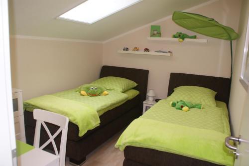 グラール・ミューリッツにあるFeWo Meerestraumの小さな部屋のベッド2台 緑のシーツ付