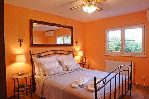 a bedroom with orange walls and a bed with a mirror at House 4 You in Lumbarda
