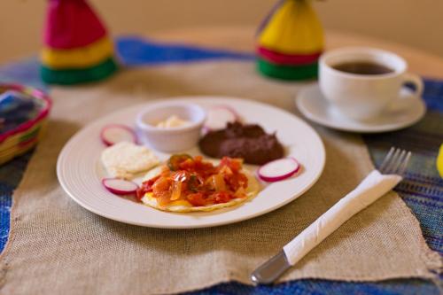 a plate of food on a table with a cup of coffee at Berakah B&B- Central Park in Copan Ruinas