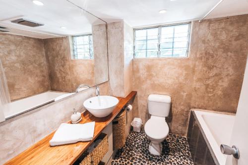 Un baño con lavabo, bañera e inodoro. en Inner City Oasis, en Cairns