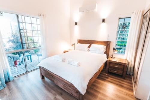 a bedroom with a large bed with white sheets at Inner City Oasis in Cairns