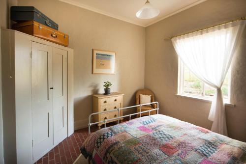 Giường trong phòng chung tại The Cottage at Riverside Farm