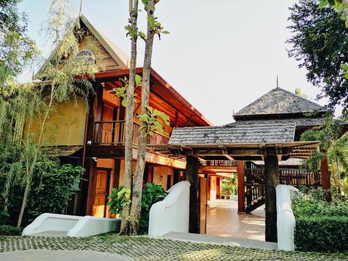 a house with a pavilion in front of it at Royal Train Garden Resort in Chiang Mai