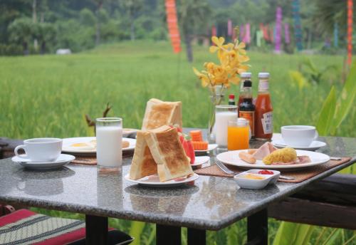 a table with plates of food and drinks on it at Royal Train Garden Resort in Chiang Mai