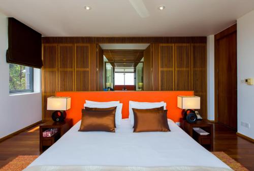 a bedroom with a large bed with an orange headboard at The heights ocean views B15 Near Kata Beach in Kata Beach