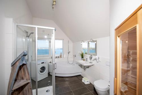 a bathroom with a shower and a sink and a toilet at Hus Twustern in Olpenitz