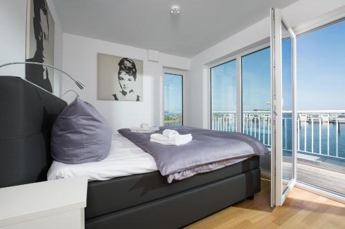 a bedroom with a bed with a view of the ocean at Küsten Lodge in Olpenitz