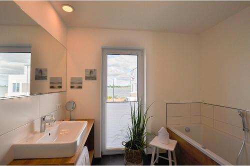 a bathroom with a tub and a sink and a bath tub at Nantucket in Olpenitz