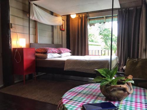 a bedroom with a bed and a table with a potted plant at Bannamhoo Bungalows in Pai