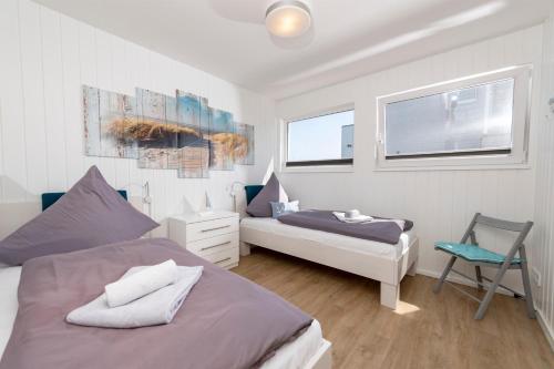 a bedroom with two beds and a chair in it at Schwimmendes Haus Sea Lounge in Olpenitz