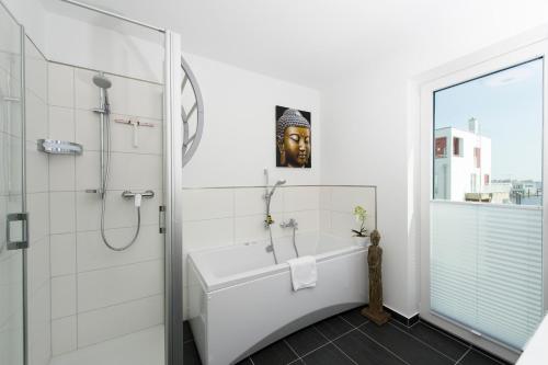 a bathroom with a shower and a bath tub with a mask at Meeresbrise in Olpenitz