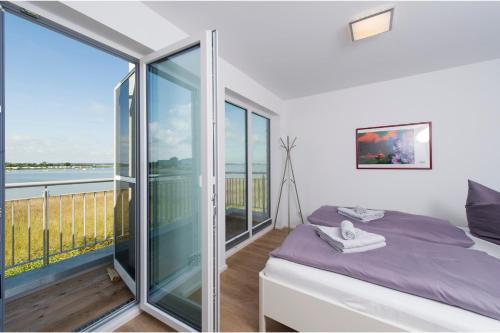 a bedroom with a bed and a view of the ocean at Villa Seensucht in Olpenitz