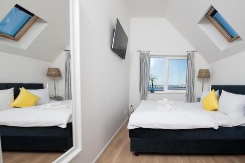 two beds in a room with a mirror at Ostsee Koje in Olpenitz