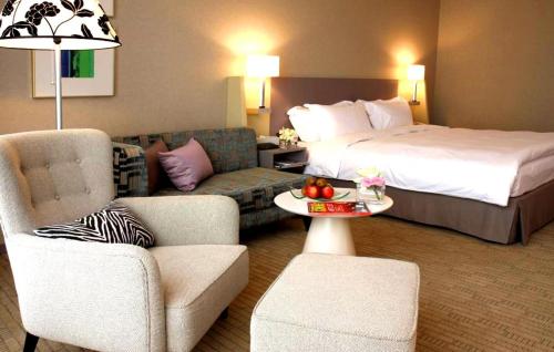 a hotel room with a bed and a living room at Hung's Mansion in Taichung