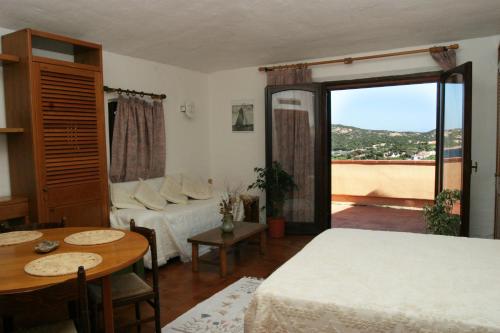 een slaapkamer met een bed en een tafel en een kamer met een raam bij Chrysalis Bay in Porto Cervo