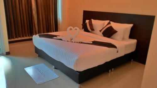 Un dormitorio con una cama con una cinta. en K2 Living Hotel en Uttaradit