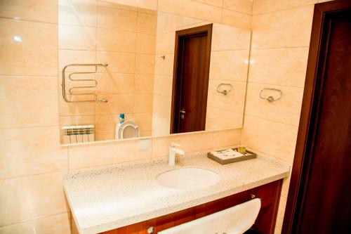 a bathroom with a sink and a mirror at Park Hotel in Qyzylorda