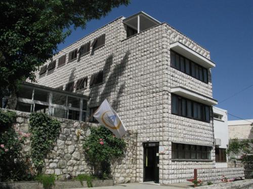 a white brick building with a sign on it at HI Hostel Dubrovnik in Dubrovnik