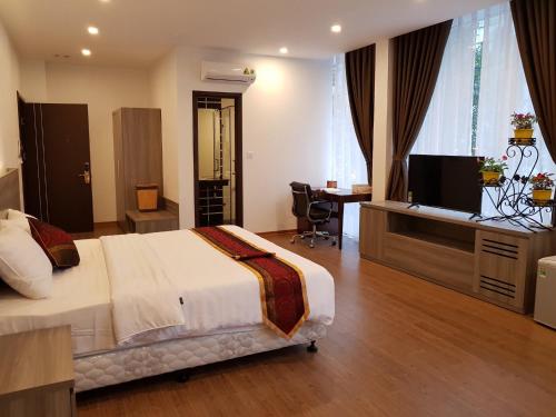 Dormitorio con cama, escritorio y TV en Soo Hotel Bac Ninh, en Bắc Ninh