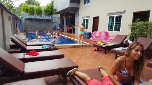 a woman laying on chairs in a swimming pool at Siem Reap Pub Hostel in Siem Reap
