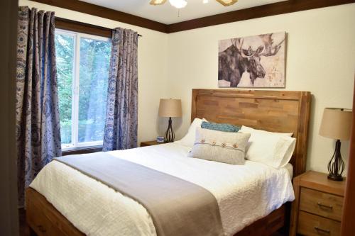 a bedroom with a large bed and a window at Bramblebank Cottages in Harrison Hot Springs