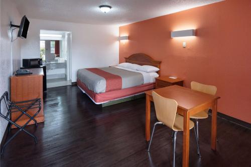a hotel room with a bed and a desk and a table at Motel 6-Montgomery, AL - Coliseum in Montgomery