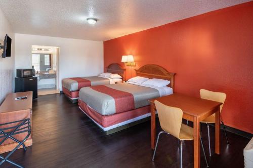 a hotel room with two beds and a table at Motel 6-Montgomery, AL - Coliseum in Montgomery