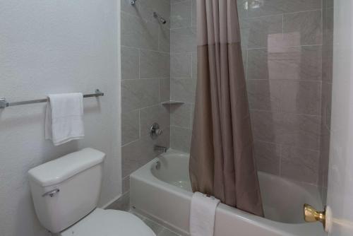 a bathroom with a toilet and a shower curtain at Motel 6-Montgomery, AL - Coliseum in Montgomery