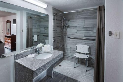 a bathroom with a sink and a chair in it at Motel 6-Montgomery, AL - Coliseum in Montgomery