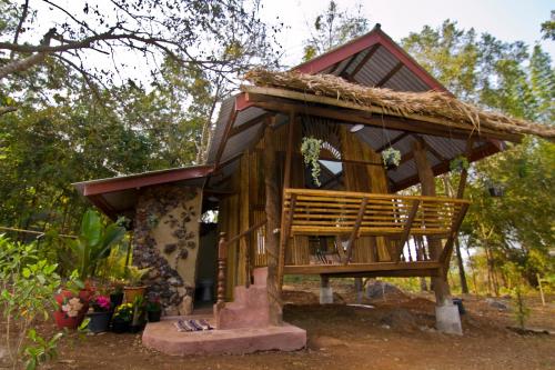 a small tree house with a thatched roof at Shanti Farm in Tha Kradan