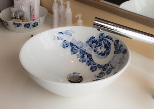 a bathroom sink with a blue and white bowl at CHAHARU Hanare Dogo Yumekura in Matsuyama