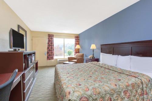a hotel room with a bed and a television at Days Inn by Wyndham Lexington in Lexington