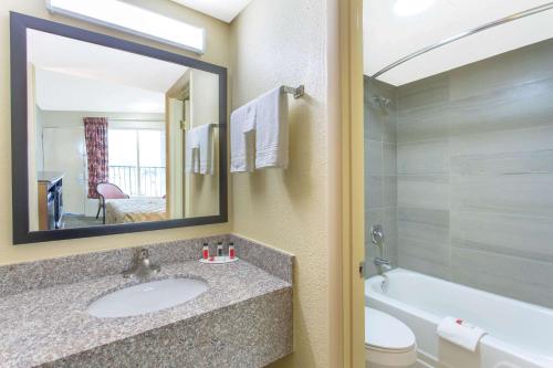 La salle de bains est pourvue d'un lavabo, d'une baignoire et de toilettes. dans l'établissement Days Inn by Wyndham Lexington, à Lexington