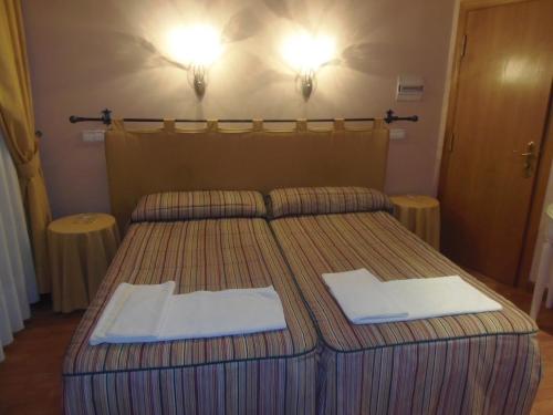 a bedroom with a bed with two towels on it at Hostal Stop in Cantalejo