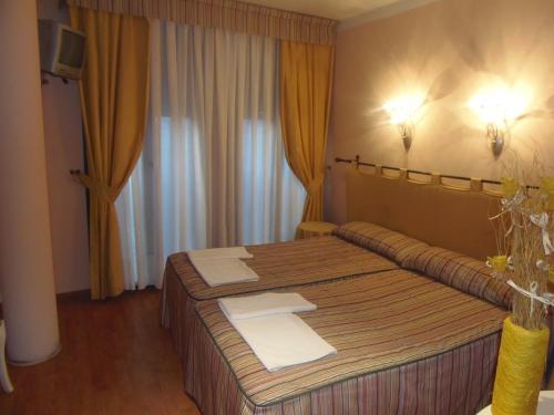a hotel room with a bed and a mirror at Hostal Stop in Cantalejo