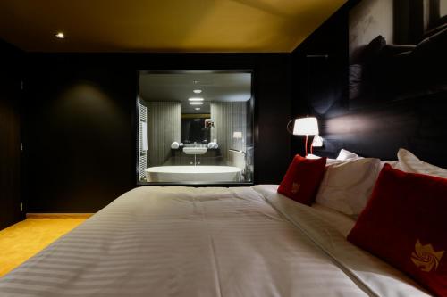 ナミュールにあるホテル ザ ロイヤル スネイルのベッドルーム(大型ベッド1台、バスタブ付)