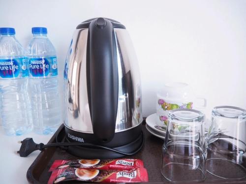 a coffee maker sitting on a counter with water bottles at Kangsadan Resort in Loei