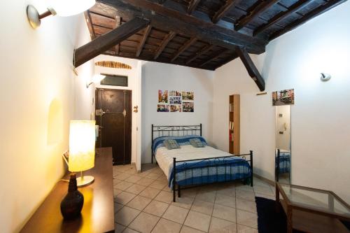 een slaapkamer met een bed en een tafel met een lamp bij JUSTACASA alla SCALA Trastevere in Rome