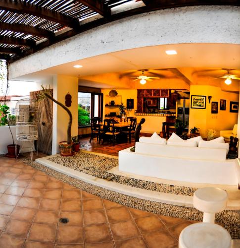 a living room with white couches and a table at Hotel Suites Ixtapa Plaza in Ixtapa